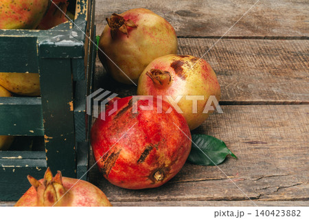 Pomegranate fruit on an old wooden background Pomegranate fruit on an old wooden background 140423882