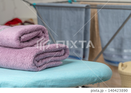 Housework concept. Ironing towels on ironing board Housework concept. Ironing towels on ironing board 140423890