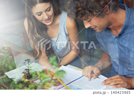 Couple, communication and study in cafe, window and research with book and indoor at student centre. Man, woman and conversation for journalism, exam or test for thinking on date, people and reading 140423985