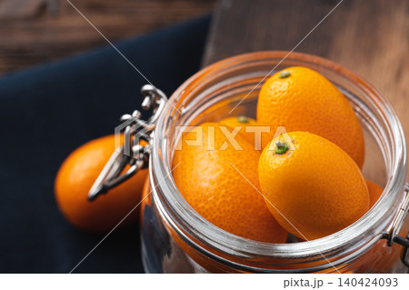 Kumquat citrus fruit on dark wooden table Kumquat citrus fruit on dark wooden table 140424093