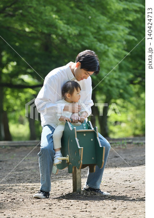 公園でスプリング遊具を楽しむ娘と父親 公園でスプリング遊具を楽しむ娘と父親 140424713