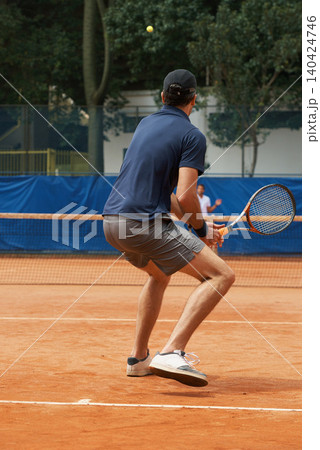 Tennis, game and man training for sport, competition or exercise for fitness on court. Athlete, workout and play on pitch outdoor in summer with action, challenge and person in contest from back Tennis, game and man training for sport, competition or exercise for fitness on court. Athlete, workout and play on pitch outdoor in summer with action, challenge and person in contest from back 140424746
