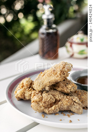 crispy breaded deep fried chicken pieces snack on white table in outdoor cafe crispy breaded deep fried chicken pieces snack on white table in outdoor cafe 140424814