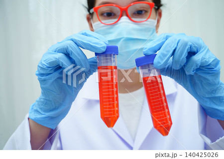 Doctor holding thyroid gland model and blood sample test tube in laboratory. Doctor holding thyroid gland model and blood sample test tube in laboratory. 140425026