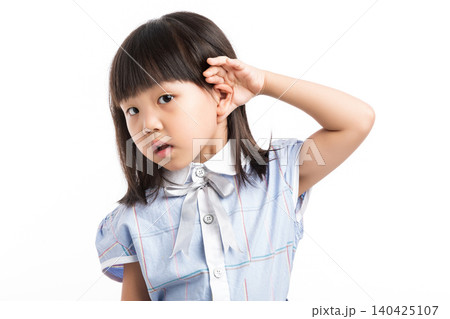 Curious little Chinese girl with pigtails holding hand to her ear, listening to something, white background. Curious little Chinese girl with pigtails holding hand to her ear, listening to something, white background. 140425107