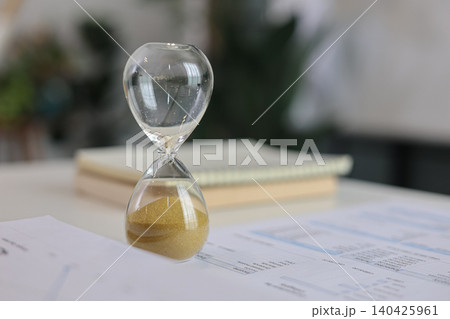 Close up of hourglass timer which run out on office desk for deadline concept. Close up of hourglass timer which run out on office desk for deadline concept. 140425961