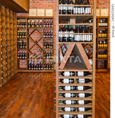 Balaklava, Crimea, Russia-June 2, 2018: Storage of wine bottles on wooden shelves in a wine shop. Collectible wine bottles Balaklava, Crimea, Russia-June 2, 2018: Storage of wine bottles on wooden shelves in a wine shop. Collectible wine bottles 140425993
