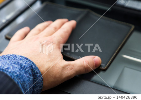 Copying Passport Pages at a Document Copy Center Office Administrative Service, A man's hand holds a document Copying Passport Pages at a Document Copy Center Office Administrative Service, A man's hand holds a document 140426890