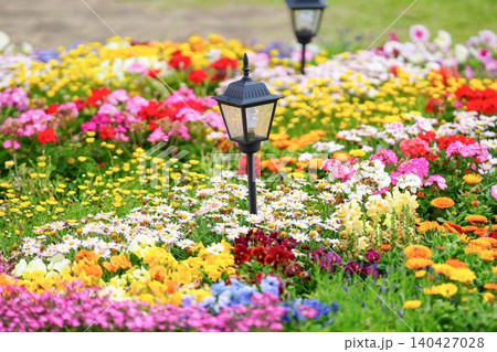 色鮮やかな花々が咲き誇る花壇とアンティーク調のガーデンライト 140427028