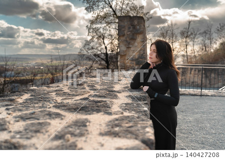 Young Woman at Historic Stone Ruins with Scenic View 140427208