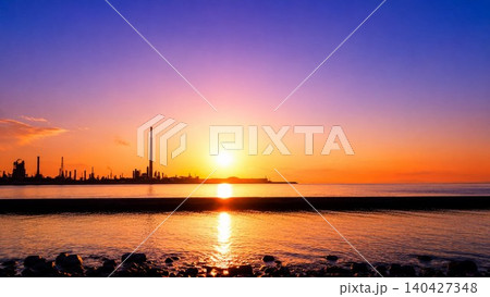 夕日に染まる海辺と工場群のシルエット風景 夕日に染まる海辺と工場群のシルエット風景 140427348