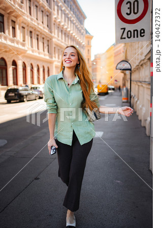 Young woman walking and smiling on a Vienna street Young woman walking and smiling on a Vienna street 140427372