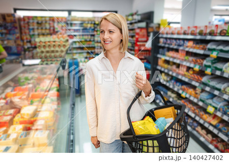 Woman shopping for groceries in supermarket aisle Woman shopping for groceries in supermarket aisle 140427402