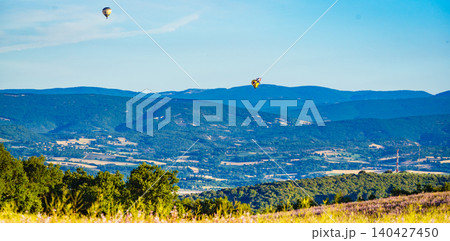 Hot air balloons float above hills and fields in the countryside. Provence in France Hot air balloons float above hills and fields in the countryside. Provence in France 140427450