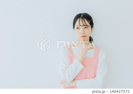 困った表情の女性保育士 140427572