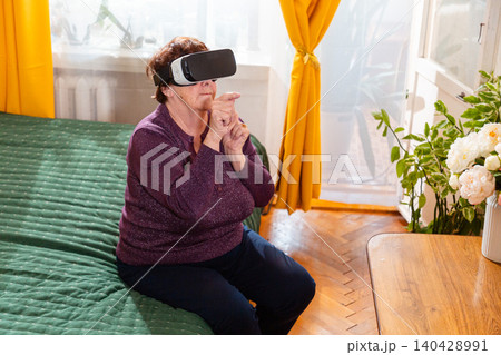 Pensioner immersed in VR experience and interactive digital simulation. Artificial intelligence concept. Technology driven elderly lifestyle. 140428991