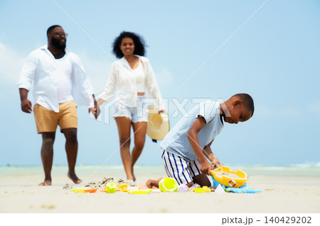 Happy Black family building sandcastle together on beach Happy Black family building sandcastle together on beach 140429202