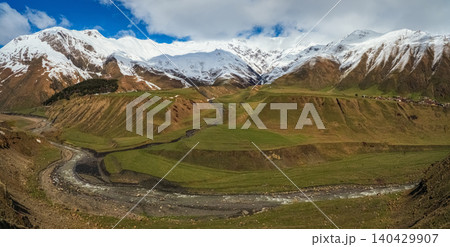 Wide panoramic view of snow-capped mountain peaks, mountain village Wide panoramic view of snow-capped mountain peaks, mountain village 140429907