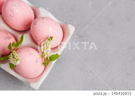 Pink eggs with flowers in a white tray on a gray surface during spring season for festive celebration and decoration Pink eggs with flowers in a white tray on a gray surface during spring season for festive celebration and decoration 140430855