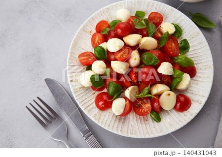 Italian caprese salad with sliced tomatoes, mozzarella, basil and olive oil Italian caprese salad with sliced tomatoes, mozzarella, basil and olive oil 140431043