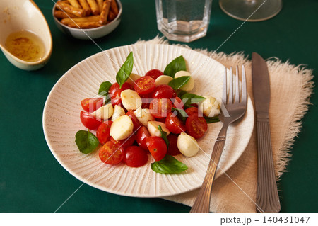 A plate of Caprese salad, tomatoes, cheese, and bread. A plate of Caprese salad, tomatoes, cheese, and bread. 140431047