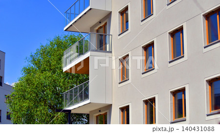 European residential architecture harmonizing with nature. Eco-friendly living in city with greens. Eco apartment building saving energy and fresh air concept.  140431088