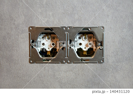 A close-up view of an electrical outlet being installed into a wall. A close-up view of an electrical outlet being installed into a wall. 140431120