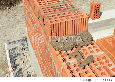 Brickwork construction in progress at a building site during daylight hours 140431343