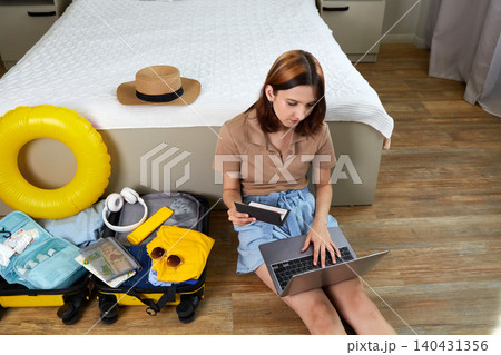 A young woman buys tickets on her laptop. Preparing for vacation, planning a trip. 140431356