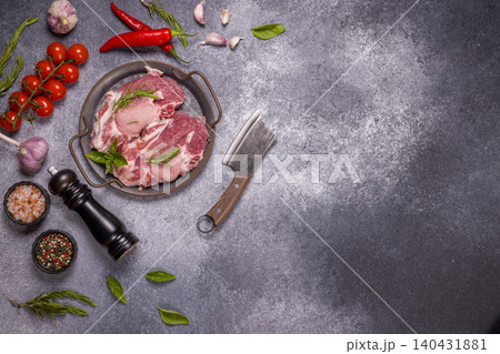 Raw pork steak, chili, garlic, spices, cleaver, and herbs preparing Raw pork steak, chili, garlic, spices, cleaver, and herbs preparing 140431881