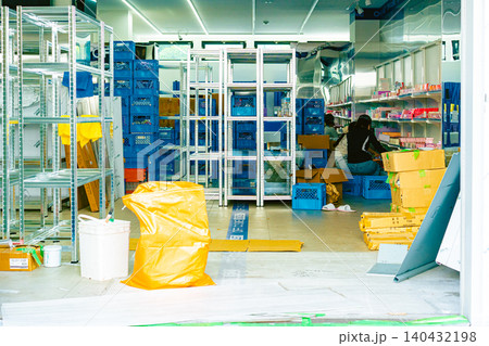 開店準備や商品の品出し陳列作業が行われている店舗（または倉庫）の店内風景 140432198