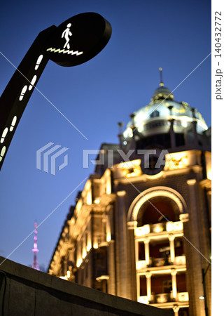 Pedestrian crossing sign and lit historic building at dusk 140432772