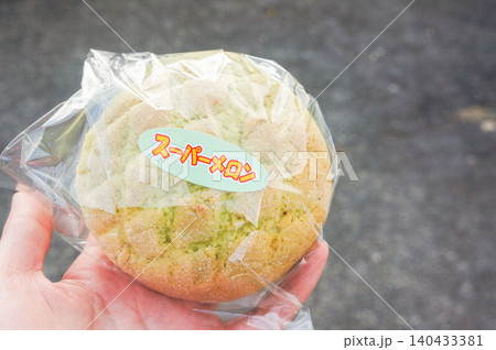手に持ったスーパーメロンパンの焼きたての甘い香り 140433381