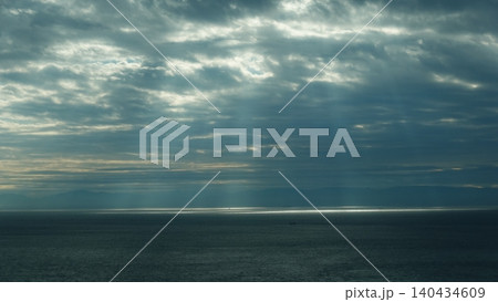 雲の隙間から海面へ降り注ぐ薄明光線 140434609