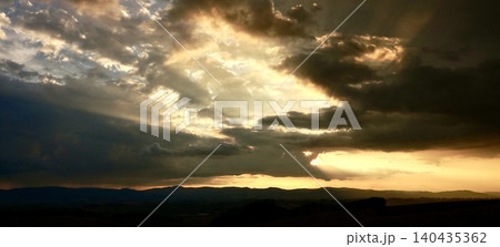 雲と光条が印象的な北海道美瑛町の丘の上から見た夕暮れの風景 雲と光条が印象的な北海道美瑛町の丘の上から見た夕暮れの風景 140435362