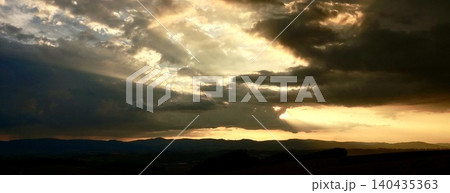 雲と光条が印象的な北海道美瑛町の丘の上から見た夕暮れの風景 雲と光条が印象的な北海道美瑛町の丘の上から見た夕暮れの風景 140435363