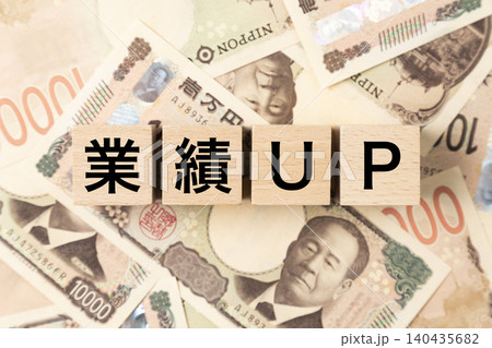 「業績UP」と書かれたブロックとたくさんの一万円札 「業績UP」と書かれたブロックとたくさんの一万円札 140435682