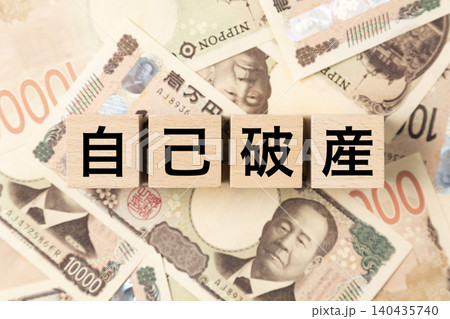 「自己破産」と書かれたブロックとたくさんの一万円札 「自己破産」と書かれたブロックとたくさんの一万円札 140435740