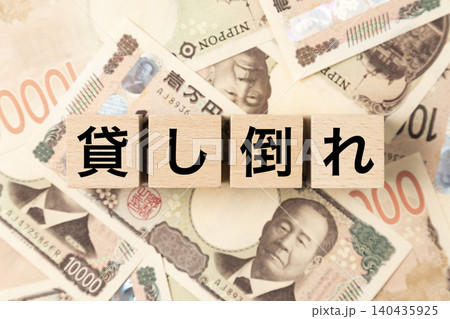 「貸し倒れ」と書かれたブロックとたくさんの一万円札 「貸し倒れ」と書かれたブロックとたくさんの一万円札 140435925
