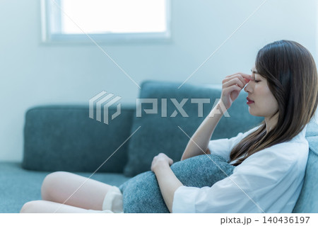 ソファでくつろぐ女性の悩み ソファでくつろぐ女性の悩み 140436197