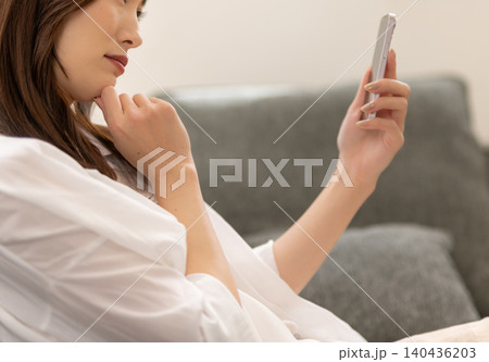 ソファでスマホを操作する女性 ソファでスマホを操作する女性 140436203