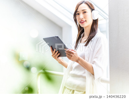 タブレットで音楽を聴く笑顔の女性 140436220