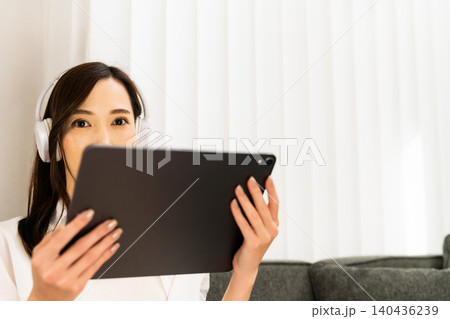 ソファでタブレットを楽しむ女性 140436239