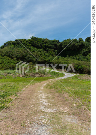 快晴の空と緑の平原の中を蛇行して緑の丘につながる道 快晴の空と緑の平原の中を蛇行して緑の丘につながる道 140436296