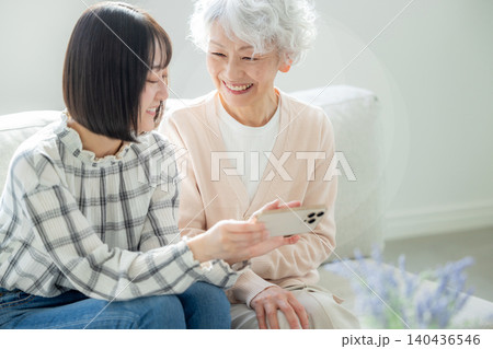 スマホを見るシニア女性と孫 スマホを見るシニア女性と孫 140436546