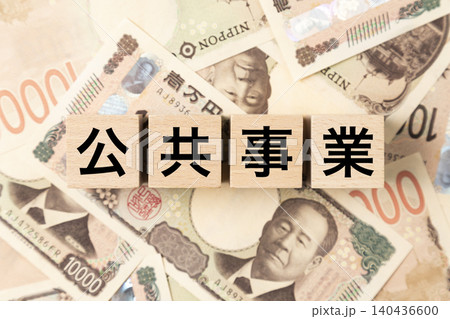 「公共事業」と書かれたブロックとたくさんの一万円札 140436600