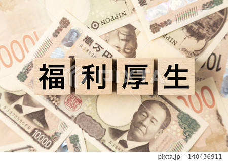 「福利厚生」と書かれたブロックとたくさんの一万円札 「福利厚生」と書かれたブロックとたくさんの一万円札 140436911