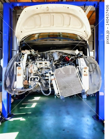 自動車整備工場のリフトでバンパーを外して点検・修理中の車のエンジンルーム 140437406
