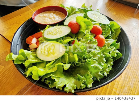 Healthy Green Salad Bowl with Sliced Cucumber Cherry Tomatoes and Sesame Sauce Healthy Green Salad Bowl with Sliced Cucumber Cherry Tomatoes and Sesame Sauce 140438437