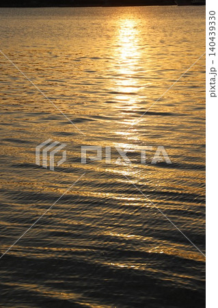 穏やかな瀬戸内海に沈む夕日と海面に美しく映えるきらめく太陽の光 140439330